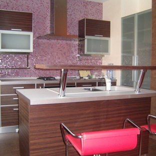 Foto de cocina de galera, actual, pequeña, abierta, con fregadero bajoencimera, puertas de armario de madera en tonos medios, encimera de laminado, salpicadero rosa, salpicadero con mosaicos de azulejos, electrodomésticos de acero inoxidable, suelo de baldosas de porcelana, una isla y suelo marrón