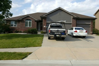 Mid-sized elegant brown one-story mixed siding house exterior photo in Omaha with a hip roof and a tile roof
