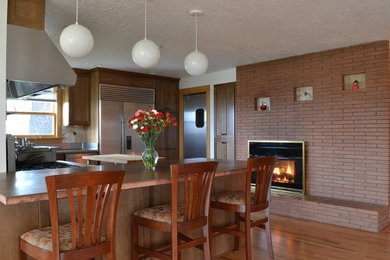 Mid-sized elegant light wood floor open concept kitchen photo in Portland with an integrated sink, shaker cabinets, brown cabinets, copper countertops, multicolored backsplash, stone tile backsplash, stainless steel appliances and a peninsula