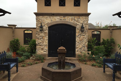 Example of a large tuscan beige one-story exterior home design in Austin