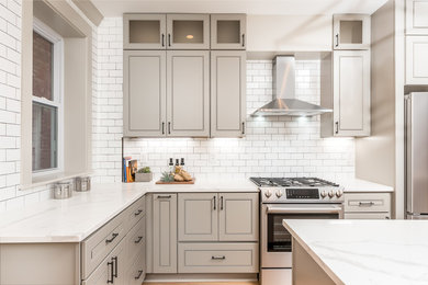 Transitional l-shaped kitchen photo in DC Metro with gray cabinets, white backsplash, stainless steel appliances, an island, white countertops and recessed-panel cabinets