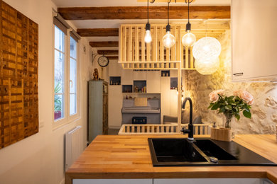 Diseño de biblioteca en casa blanca y madera clásica renovada pequeña sin chimenea con suelo de cemento, suelo gris, vigas vistas y paredes beige