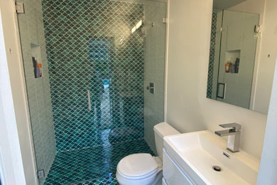 Inspiration for a small timeless 3/4 blue tile and mosaic tile mosaic tile floor, blue floor and single-sink walk-in shower remodel in Miami with flat-panel cabinets, white cabinets, a two-piece toilet, white walls, an integrated sink, a hinged shower door, white countertops and a floating vanity