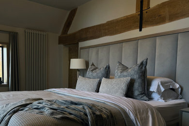 Inspiration for a large modern master bedroom in West Midlands with beige walls, carpet, exposed beams and feature lighting.