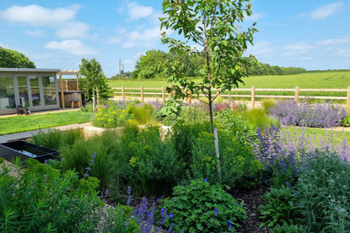 Inspiration for a medium sized country back formal partial sun garden for autumn in Cheshire with a flowerbed and decorative stones.