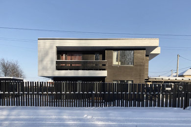 На фото: двухэтажный, деревянный, черный частный загородный дом среднего размера в скандинавском стиле с плоской крышей и отделкой доской с нащельником с