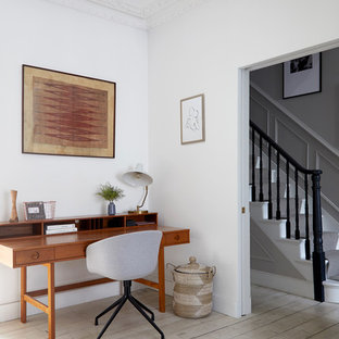 Idéer för ett stort 60 tals hemmabibliotek, med vita väggar, målat trägolv, en öppen vedspis, ett fristående skrivbord och beiget golv