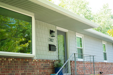 Inspiration for a mid-sized timeless gray one-story wood house exterior remodel in Kansas City with a hip roof and a shingle roof