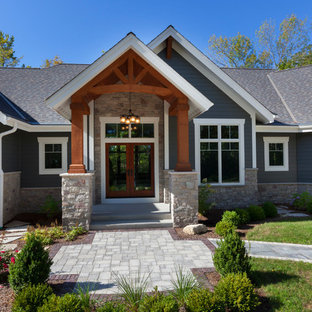 На фото: большой, одноэтажный фасад дома синего цвета в стиле кантри с двускатной крышей и крышей из гибкой черепицы с