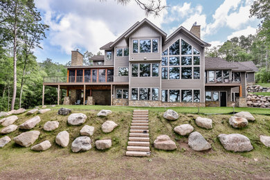 Example of a classic beige two-story exterior home design in Other with a metal roof and a brown roof