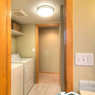 シアトルの小さいトランジショナルスタイルのおしゃれな家事室 (シェーカースタイル扉のキャビネット、中間色木目調キャビネット、人工大理石カウンター、緑の壁、磁器タイルの床、左右配置の洗濯機・乾燥機) の写真