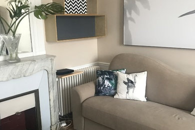Réalisation d'un bureau ethnique de taille moyenne avec un mur beige, parquet clair, une cheminée standard, un manteau de cheminée en bois et un sol marron.