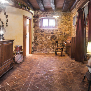 Imagen de sótano con puerta mediterráneo, de tamaño medio, con paredes multicolor, suelo de ladrillo y suelo marrón