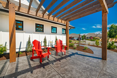 Imagen de patio minimalista de tamaño medio en patio trasero con losas de hormigón y pérgola
