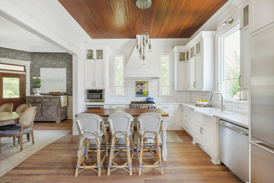 Inspiration for a cottage medium tone wood floor and wood ceiling kitchen remodel in Houston with a farmhouse sink, white cabinets, quartz countertops, white backsplash, stainless steel appliances and an island