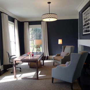 Modern inredning av ett mellanstort hemmabibliotek, med grå väggar, en standard öppen spis, en spiselkrans i metall, ett fristående skrivbord, mörkt trägolv och brunt golv