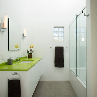 Idee per una stanza da bagno moderna di medie dimensioni con ante lisce, ante bianche, vasca ad alcova, vasca/doccia, WC a due pezzi, piastrelle grigie, piastrelle in gres porcellanato, pareti bianche, pavimento in gres porcellanato, lavabo sottopiano, top in superficie solida e top verde