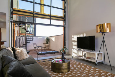 Living room - mid-century modern loft-style concrete floor and gray floor living room idea in San Diego with white walls