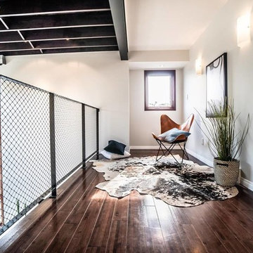 Loft space overlooks living room below, exposed steel beams help to define space