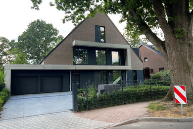 Großes, Einstöckiges Modernes Einfamilienhaus mit Backsteinfassade, grauer Fassadenfarbe, Satteldach und Ziegeldach in Hamburg
