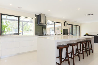 Design ideas for a mid-sized modern l-shaped eat-in kitchen in Melbourne with a double-bowl sink, recessed-panel cabinets, white cabinets, quartz benchtops, grey splashback, glass sheet splashback, stainless steel appliances, porcelain floors and with island.