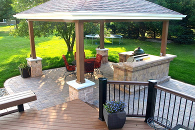 Inspiration for a large contemporary backyard stone patio kitchen remodel in Other with a gazebo