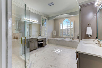 Bathroom - huge transitional master marble floor bathroom idea with white cabinets, a one-piece toilet, gray walls, an undermount sink, quartzite countertops, a hinged shower door, white countertops and a built-in vanity