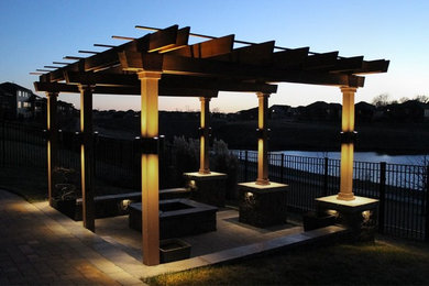Inspiration for a contemporary back patio in Omaha with a fire feature, brick paving and a pergola.