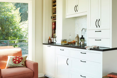 Example of a classic dark wood floor wet bar design in Seattle with shaker cabinets, white cabinets and white backsplash