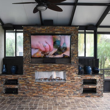 Screened in pool area addition with TV and fireplace.