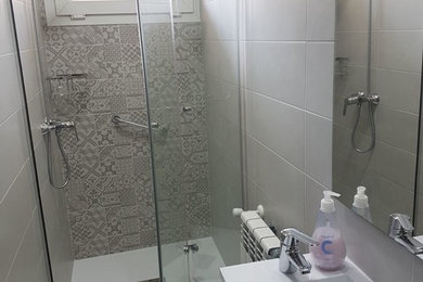 マドリードにある小さなコンテンポラリースタイルのおしゃれなトイレ・洗面所 (白いタイル、セラミックタイル、マルチカラーの床) の写真