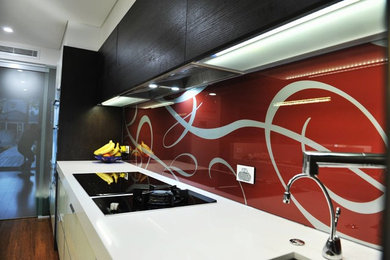 Design ideas for a modern kitchen in Sydney with glass sheet splashback.