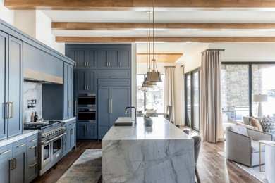 Minimalist open concept kitchen photo in Salt Lake City with a farmhouse sink, shaker cabinets, quartzite countertops, stone tile backsplash and an island