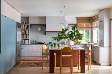 Inspiration for a mid-sized eclectic light wood floor eat-in kitchen remodel in New York with flat-panel cabinets, gray cabinets, quartzite countertops, gray backsplash, ceramic backsplash, stainless steel appliances, an island and gray countertops