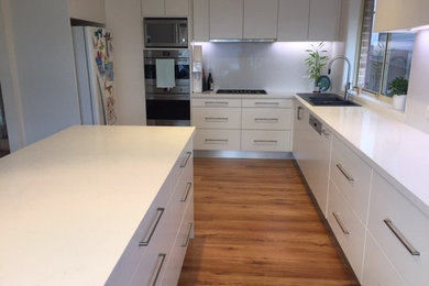Mid-sized contemporary l-shaped kitchen pantry in Sydney with a double-bowl sink and with island.