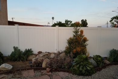 Medium sized classic back xeriscape partial sun garden for summer in Los Angeles with a garden path and natural stone paving.