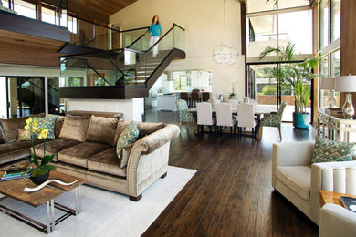 Photo of a large transitional open concept living room in Los Angeles with beige walls, dark hardwood floors, a standard fireplace and brown floor.