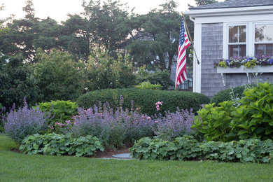 Inspiration for a mid-sized traditional backyard partial sun garden in Boston with mulch.