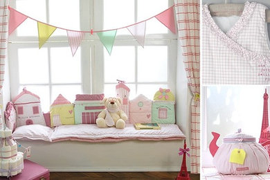 Diseño de habitación de bebé niña romántica de tamaño medio con paredes blancas y suelo de madera en tonos medios