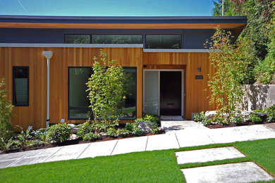 Small modern brown two-story wood exterior home idea in Portland