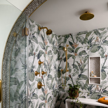 Arched Walk-In Shower with Botanical Tile and Brass Fixtures