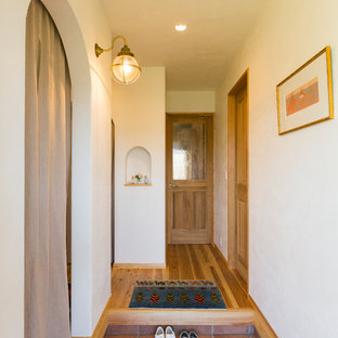 名古屋のラスティックスタイルのおしゃれな玄関ホール (白い壁、テラコッタタイルの床、茶色い床) の写真