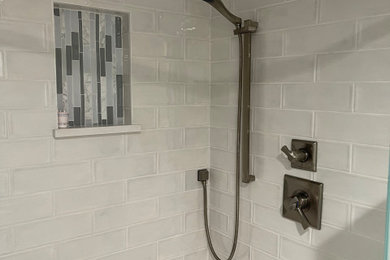 Inspiration for a large modern white tile and porcelain tile porcelain tile and single-sink bathroom remodel in Orlando with recessed-panel cabinets, gray cabinets, a two-piece toilet, white walls, an undermount sink, marble countertops, a hinged shower door, a niche and a freestanding vanity