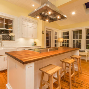 Неиссякаемый источник вдохновения для домашнего уюта: большая параллельная кухня в стиле кантри с кладовкой, раковиной в стиле кантри, фасадами в стиле шейкер, белыми фасадами, столешницей из дерева, белым фартуком, фартуком из плитки мозаики, техникой из нержавеющей стали, паркетным полом среднего тона, островом и оранжевым полом