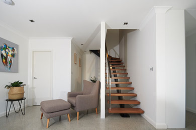 This is an example of a wood staircase in Sydney with open risers and metal railing.