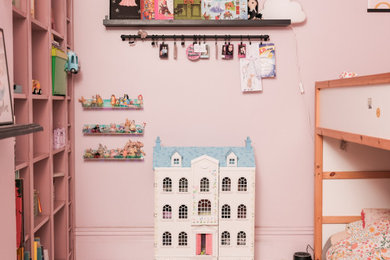 Example of a mid-sized eclectic girl white floor kids' room design in Other with pink walls