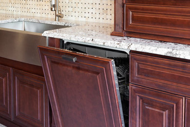 Example of a mid-sized classic single-wall linoleum floor and beige floor enclosed kitchen design in Orange County with a farmhouse sink, raised-panel cabinets, dark wood cabinets, granite countertops, beige backsplash, ceramic backsplash and stainless steel appliances