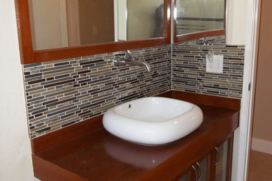 Mid-sized trendy matchstick tile ceramic tile bathroom photo in Los Angeles with glass-front cabinets, dark wood cabinets, white walls, a vessel sink and wood countertops