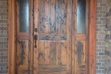 Example of a mid-sized mountain style entryway design in Other with a dark wood front door