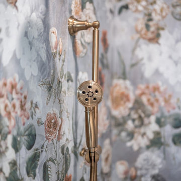 Detail of Gold Handheld Shower Against Oversized Floral Tile